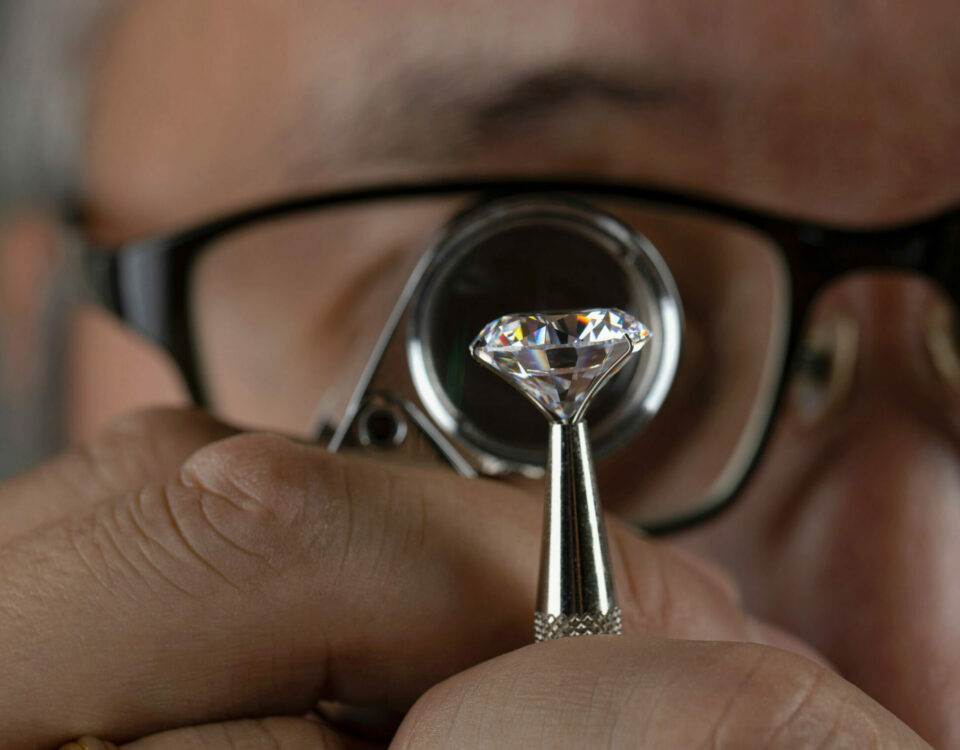 Jewelry expert appraising a loose diamond through a loop.