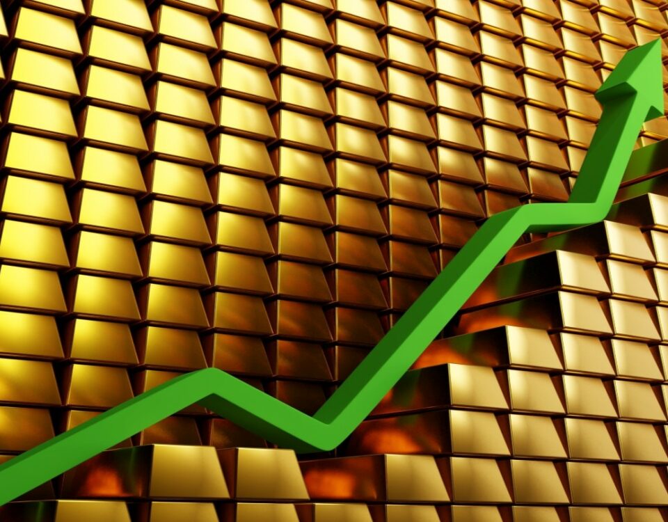 Stack of gold bars with line graph showing the rise of gold value.