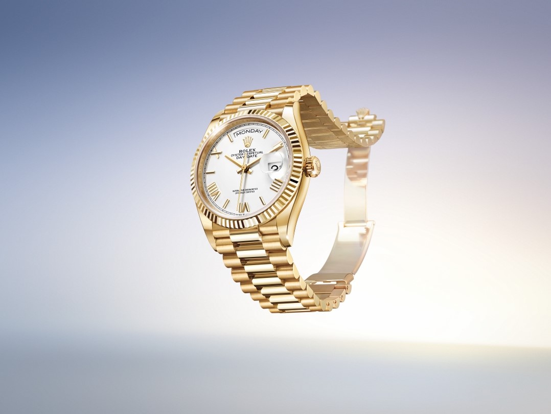 Gold luxury Rolex watch on a reflective surface used as collateral for a loan at Qollateral.