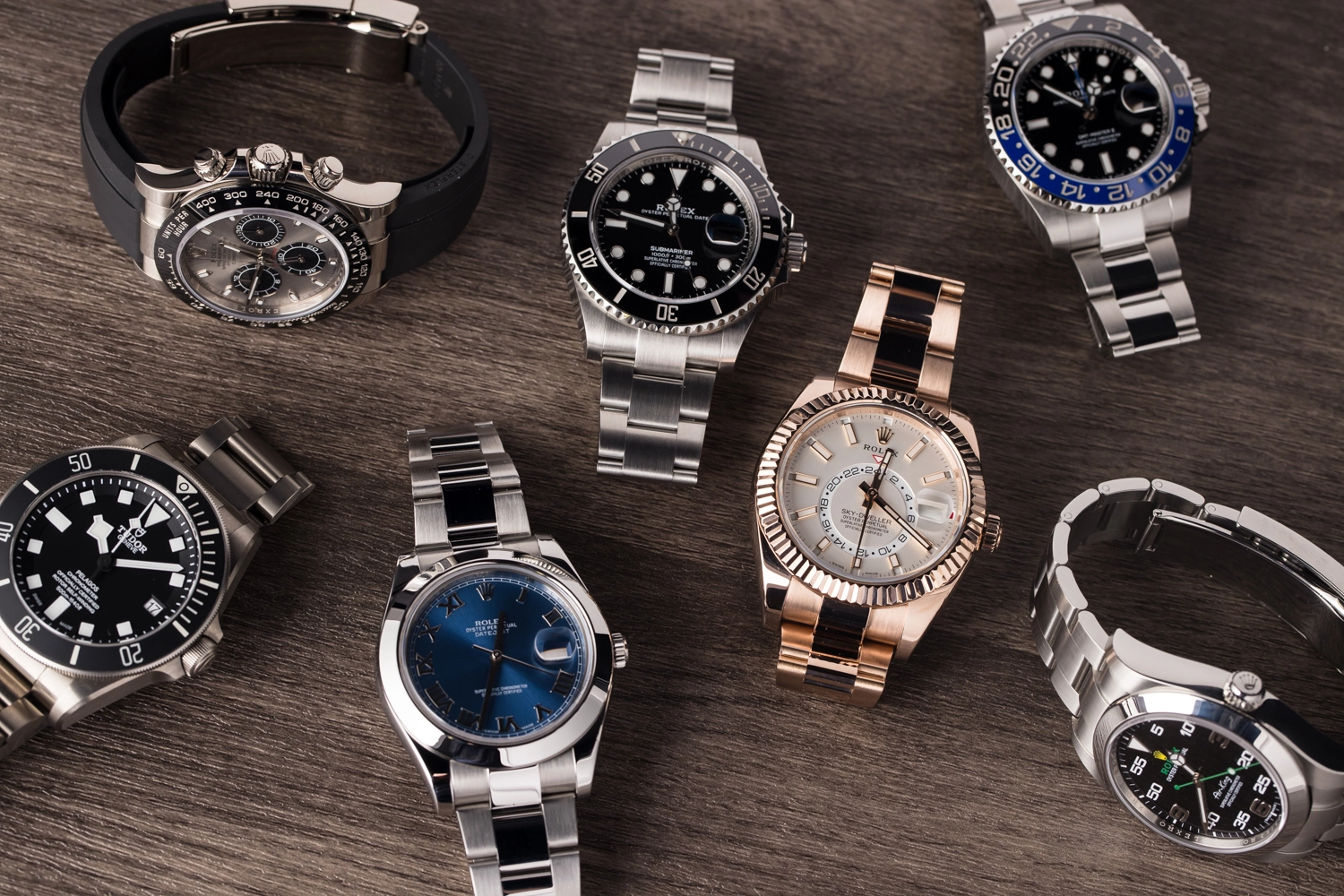 Collection of Rolex watches displayed on wood, representing high-value assets for collateral lending at Qollateral.
