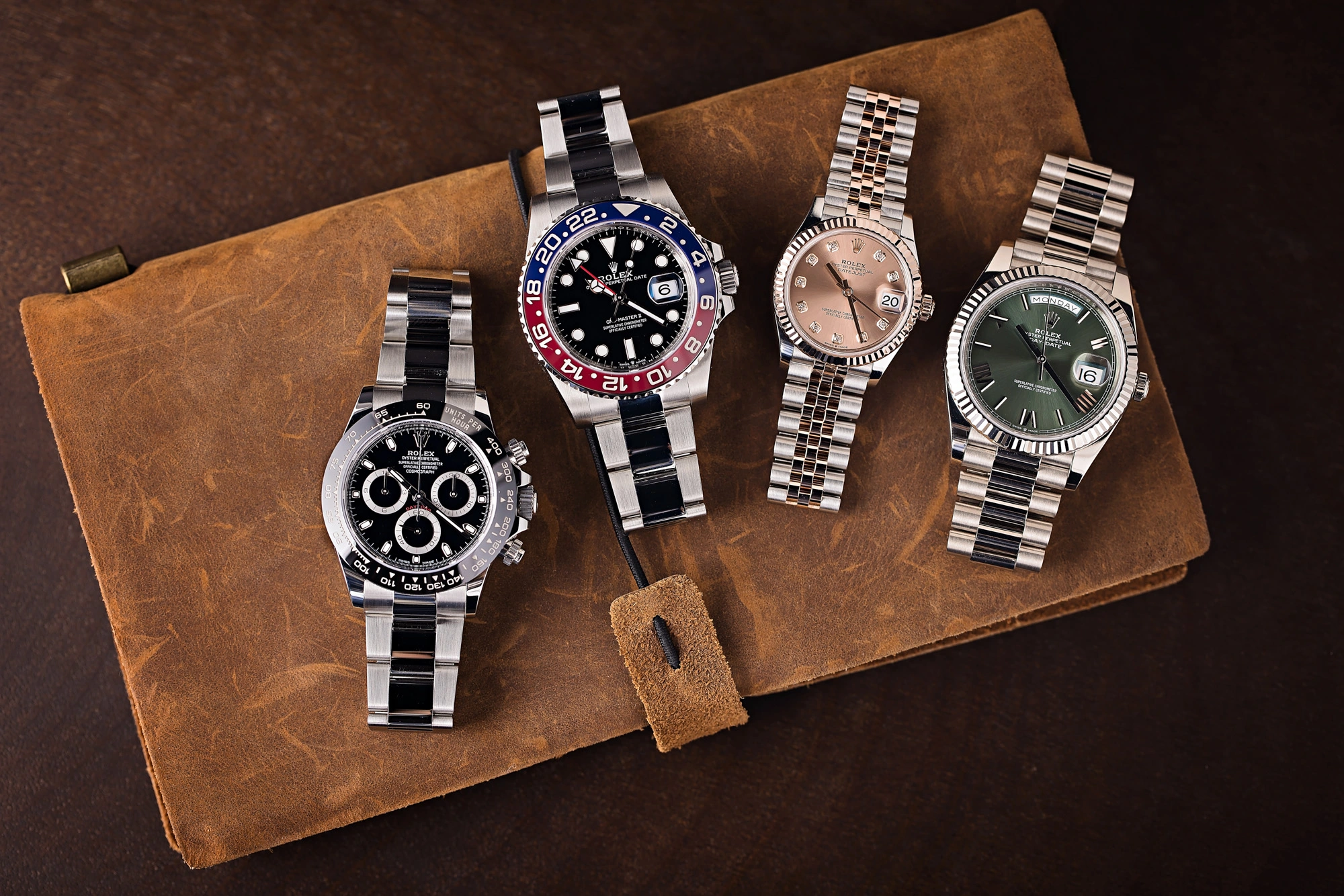 Four Rolex watches on leather case showing models that impact seasonal loan values and collateral offers.