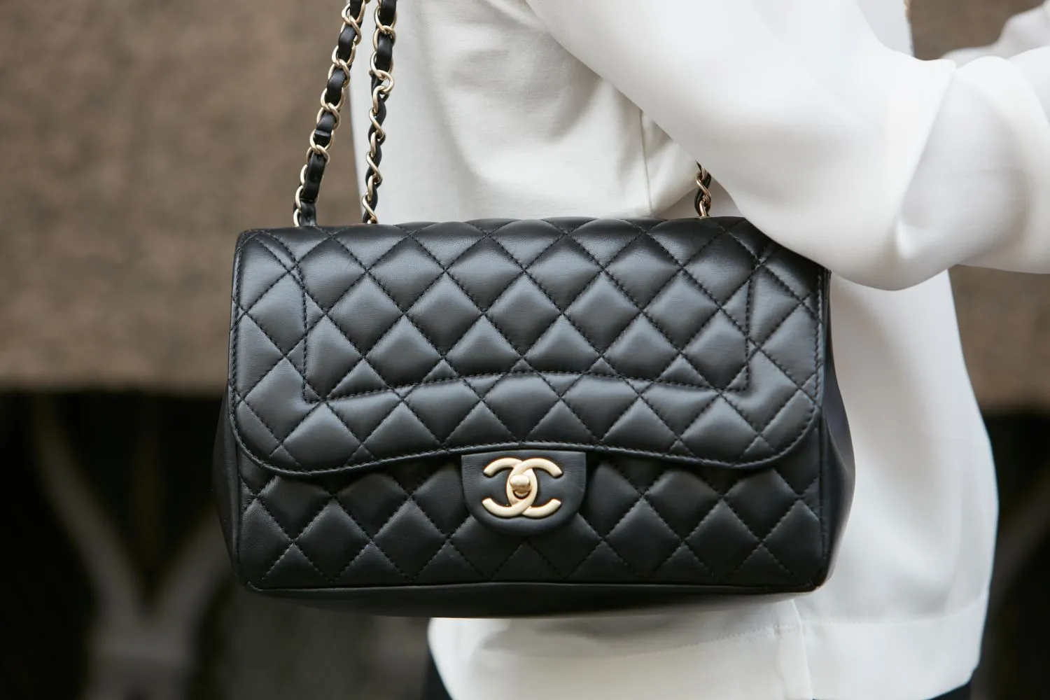 Black Chanel Classic Flap handbag with quilted leather and gold CC logo, used as collateral for a luxury handbag loan at Qollateral.
