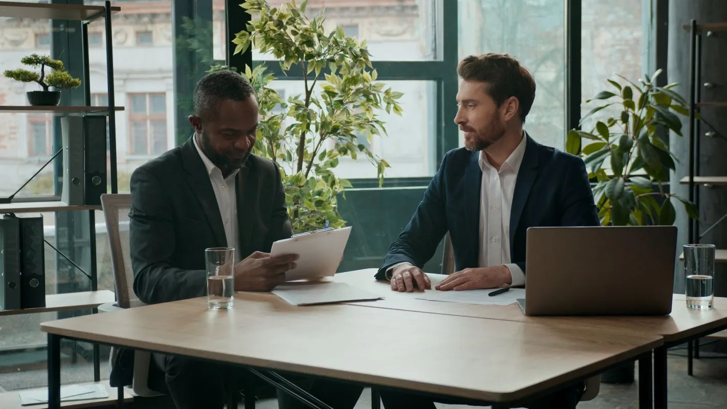 Two professionals reviewing documents during a collateral loan agreement meeting