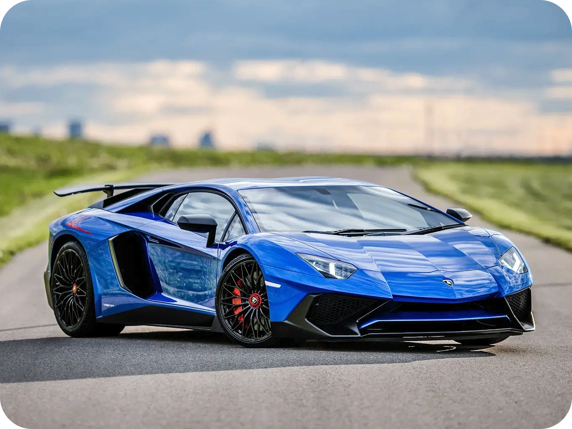Blue Lamborghini Aventador SV with rear wing on an open road