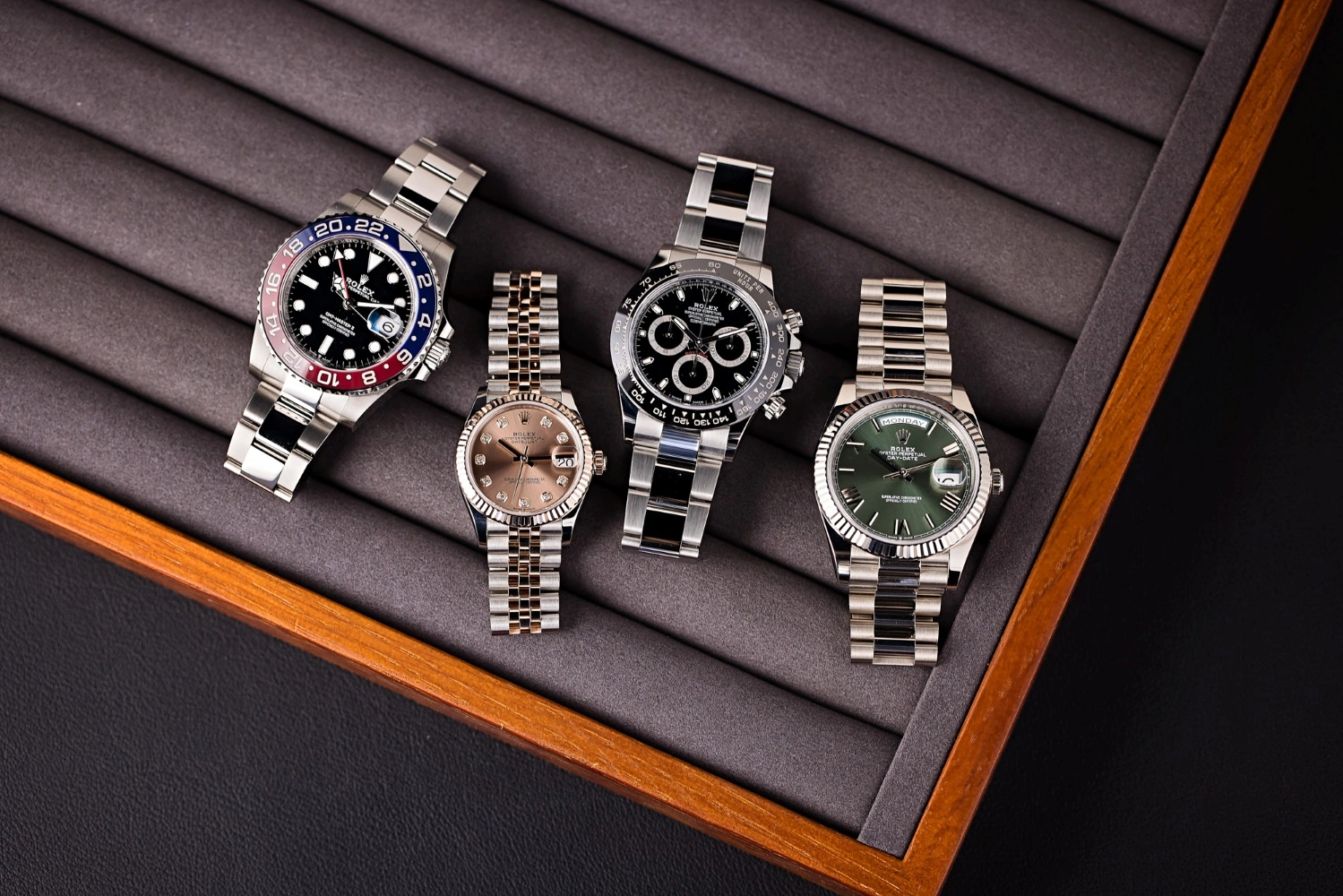 Luxury Rolex watches including Daytona, GMT-Master II, Datejust, and Day-Date displayed in a watch tray