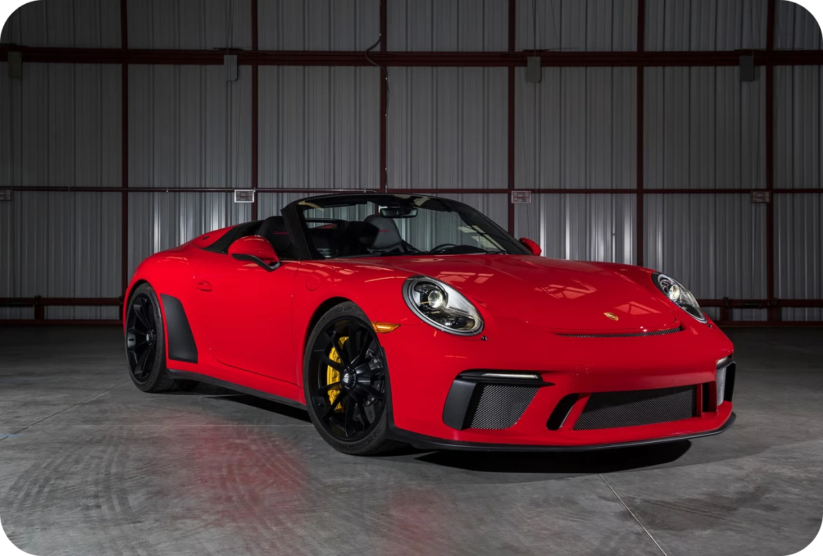 Red Porsche 911 Speedster open-top sports car parked in a hangar