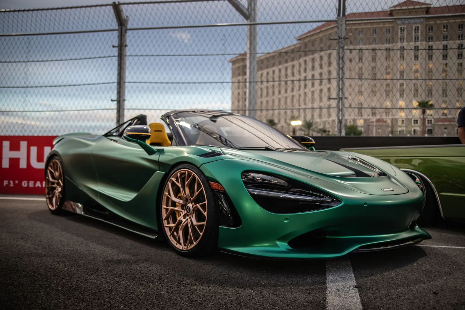 Green McLaren 750S Spider with bronze wheels parked at a car event